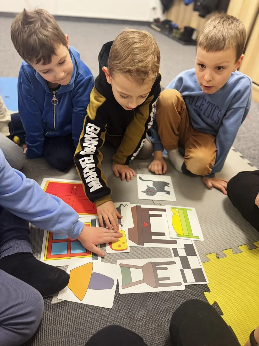 Chłopcy układają materiały edukacyjne Leo English